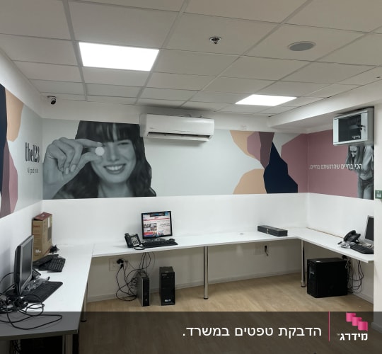 קיר עם עיצוב גרפי צבעוני ודמות אישה מחייכת